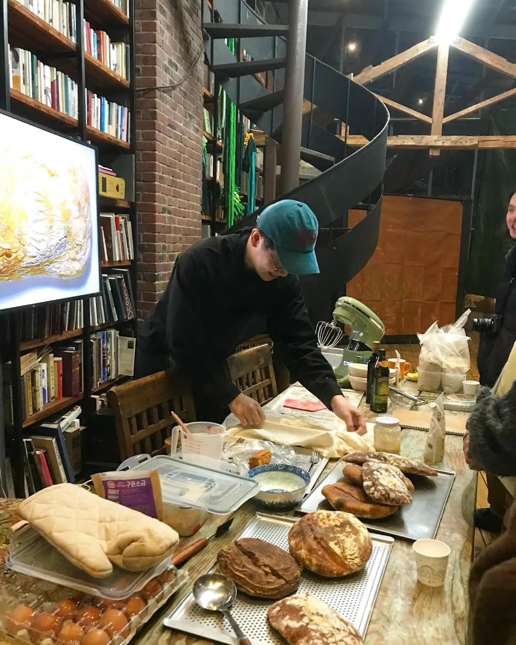 Bread Whispers — Gwangju: working dough at a table with bread and baking equipment